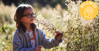 child smelling flower