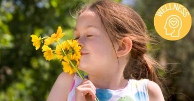 child smelling flower