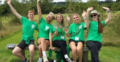 Activity camp instructors smiling with arms in the air