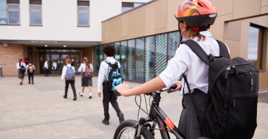 Child on a bike entering a school