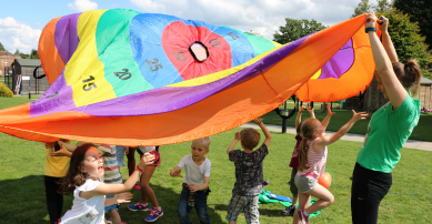 Children playing with parachute at summer camp