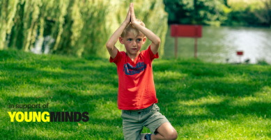 Boy doing yoga on the grass