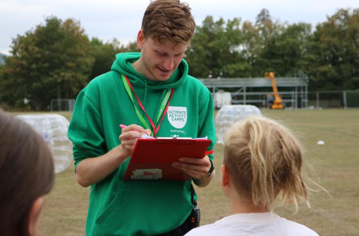 Man working on camp focussed on clipboard