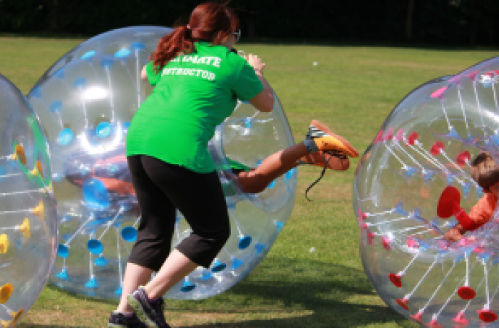 A staff member having fun helping children zorb
