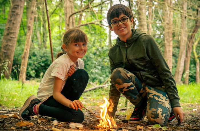 a girl and boy starting a fire