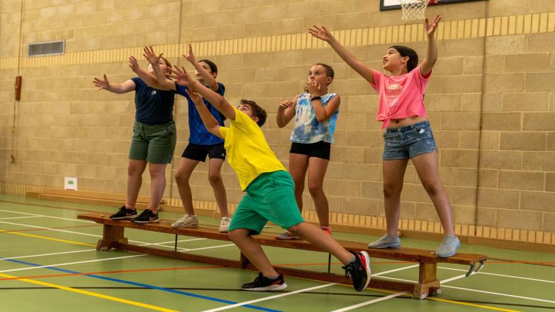 Group of children playing benchball indoors