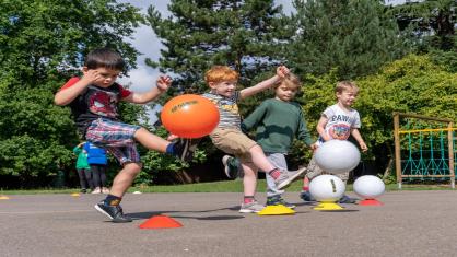 Young children kicking balls